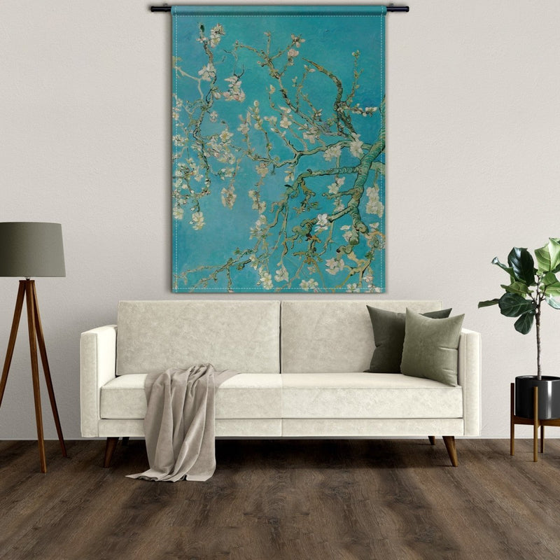 Het Amandelbloesem wandkleed is wit gestikt en hangt hier boven de bank in een Scandinavische inrichting. De kleuren uit het muurkleed passen perfect bij het lichte interieur. 