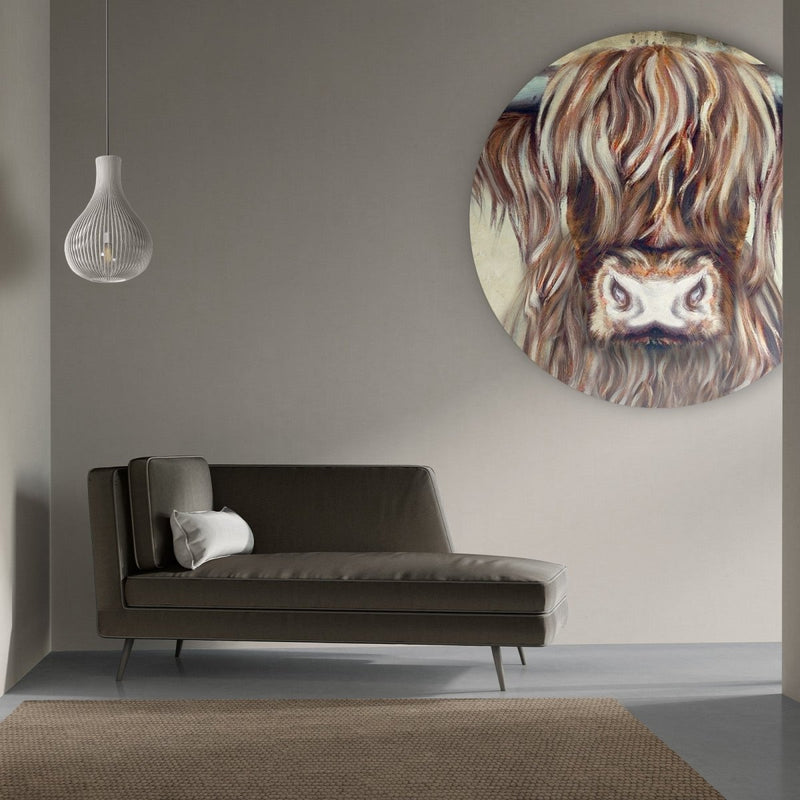 Aan een beige muur hangt het Schotse hooglander schilderij op muurcirkel van aluminium. De cirkel op muur woonkamer toont het ontwerp, Colin