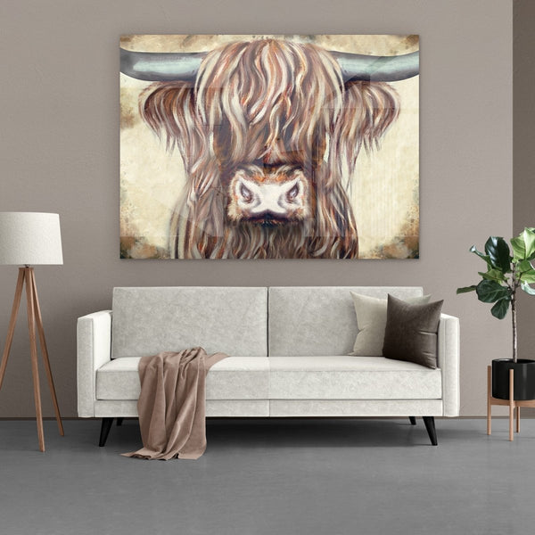 Het plexiglas schilderij van een Schotse hooglander stier hangt hier boven een bank tegen beige muur