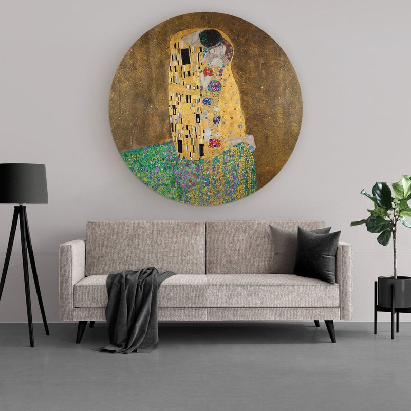De kus van Gustav Klimt op muurcirkel van aluminium dibond in de kleur goud, geel en groen. Het moderne kunstwerk met ronde vorm hangt hier in de woonkamer. 