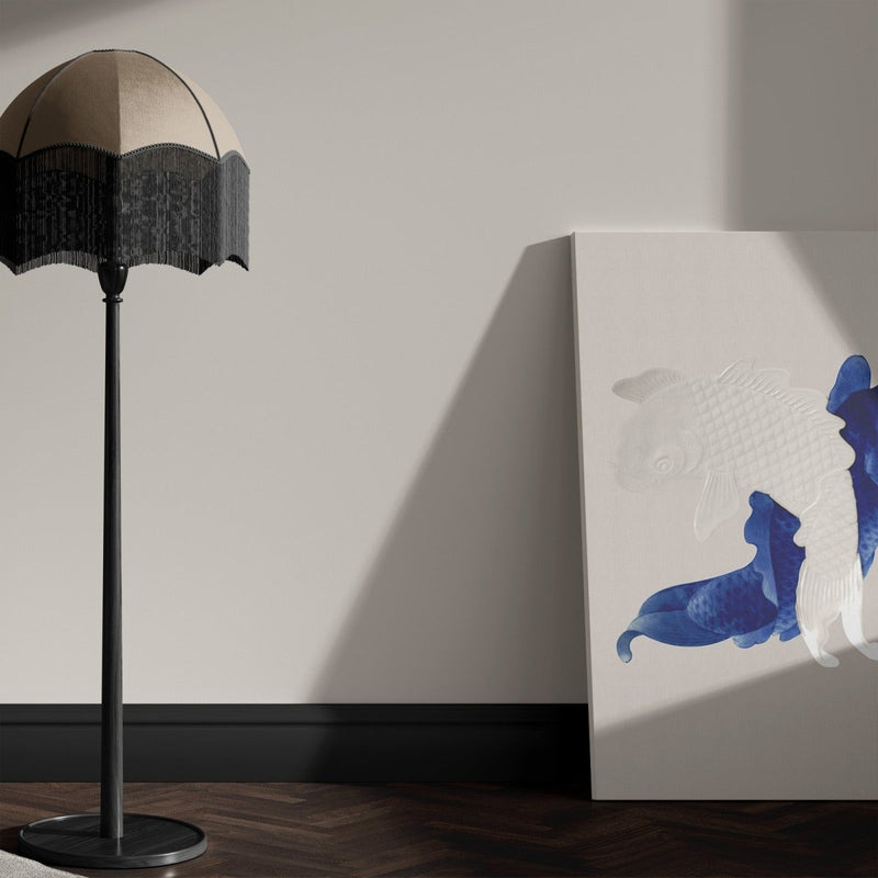 Hier zie je het blauwe schilderij met karpers op de grond staan. Het werk is gemaakt van canvas.