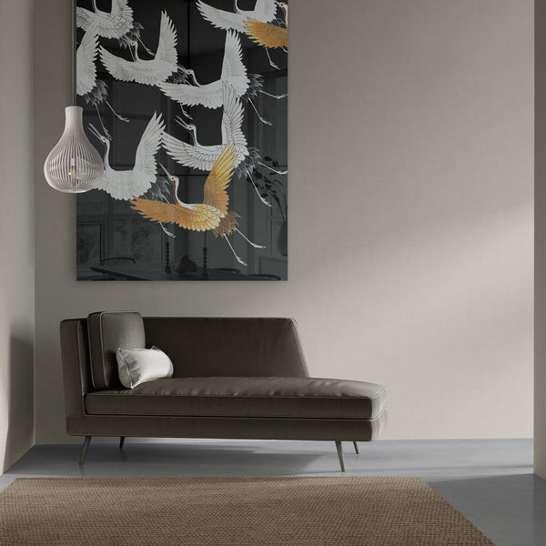 Groot plexiglas schilderij met kraanvogels in zwart en goud. De prachtige vogels stijgen op en vliegen zo je woonkamer uit. Hier hangt de plexiglas wanddecoratie boven de bank in een japandi woonstijl.