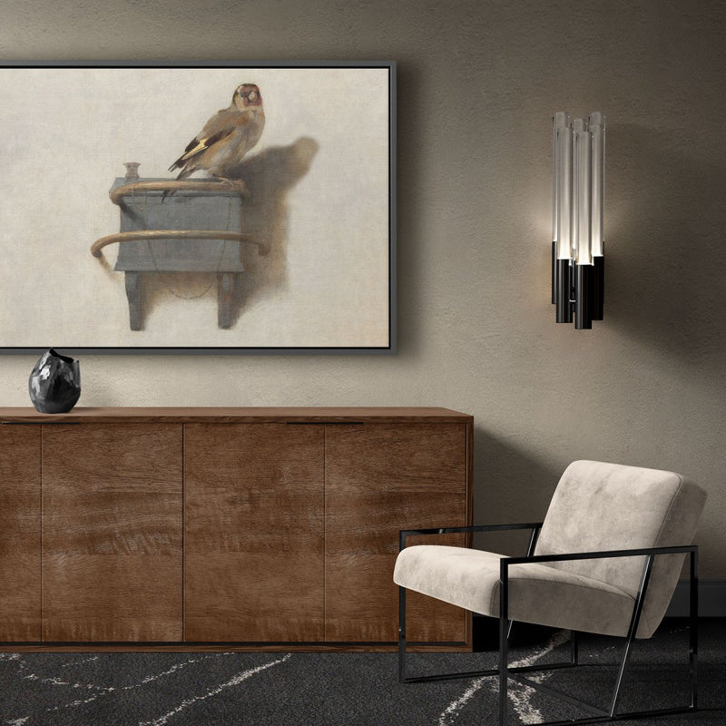 het puttertje op canvas schilderij met zwarte lijst boven een dressoir in de woonkamer. Het schilderij met het bekende vogeltje is een distelvink en gemaakt door Carel Fabritius.