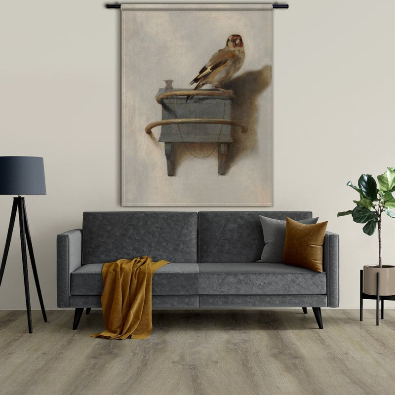 Hier hangt het Puttertje op wandkleed boven de bank in de woonkamer in de kleur beige met bruin en koper details.