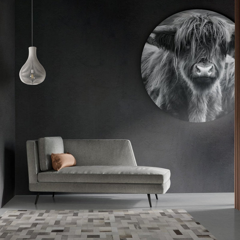 Rond schotse hooglander schilderij tegen een zwarte muur in een modern interieur 