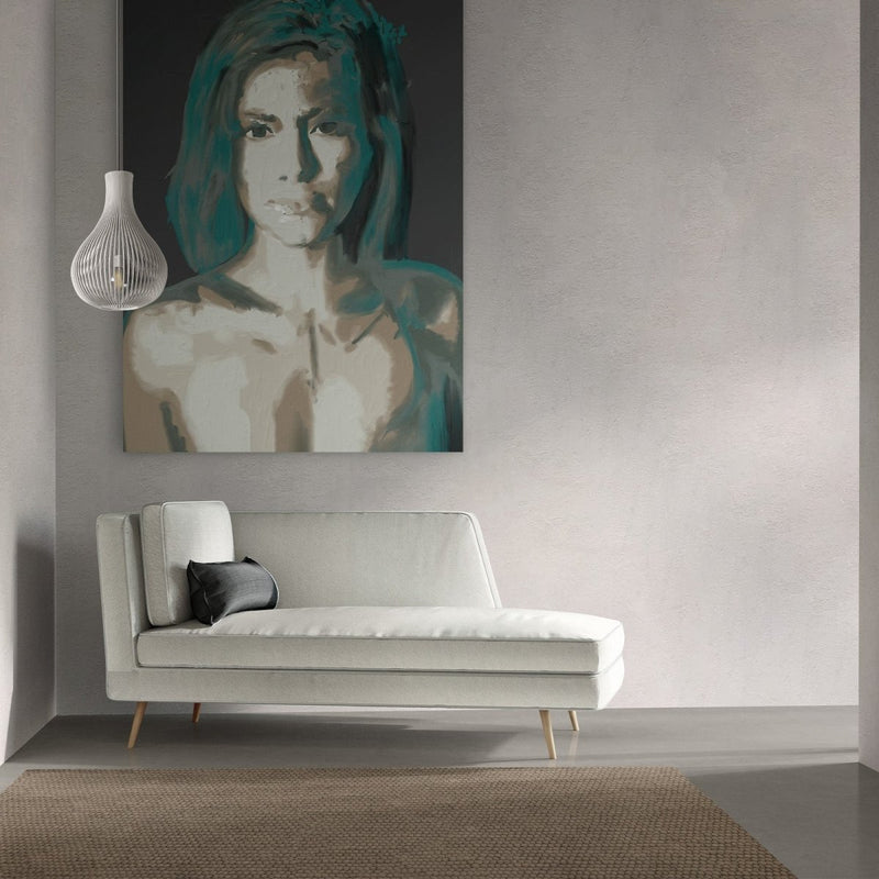 Hier hangt het vrouwen portret boven een bank aan een witte muur. Het moderne kunst schilderij valt onder moderne kunst.